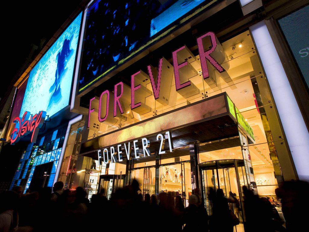Times Square night scene with glowing Forever 21 store Disney display and busy urban crowd wallpaper