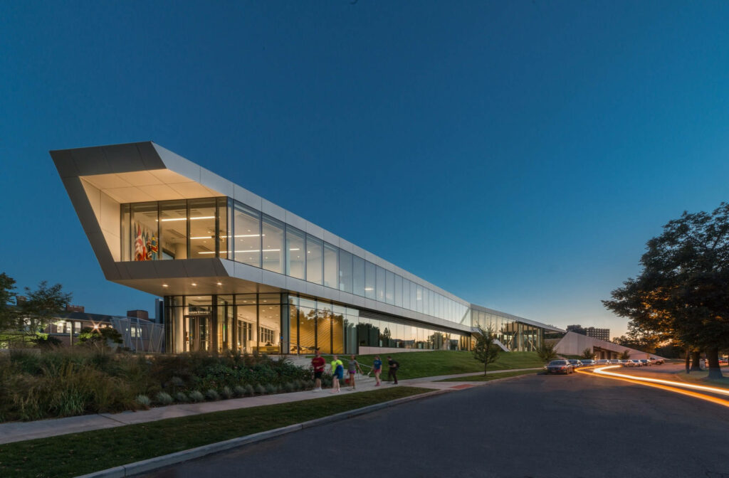Tinkham Veale University Center modern glass architecture at dusk with glowing lights and blue sky Wallpaper