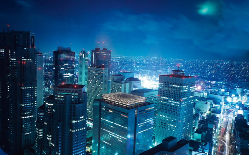 Aerial night view of Tokyo Shinjuku skyscrapers glowing in cool blue urban cityscape wallpaper