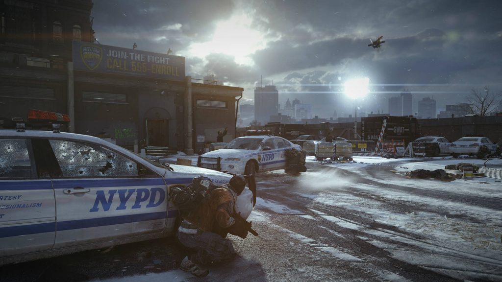 Tom Clancy The Division agent crouching behind damaged NYPD cruiser in snowy post apocalyptic NYC Wallpaper