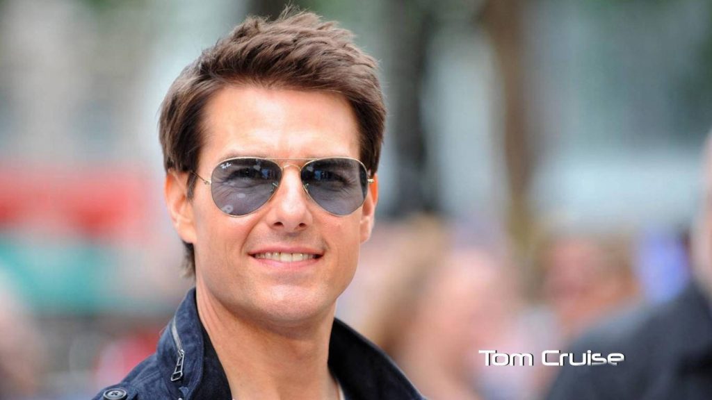 Tom Cruise portrait wearing aviator sunglasses and dark jacket in natural outdoor lighting Wallpaper