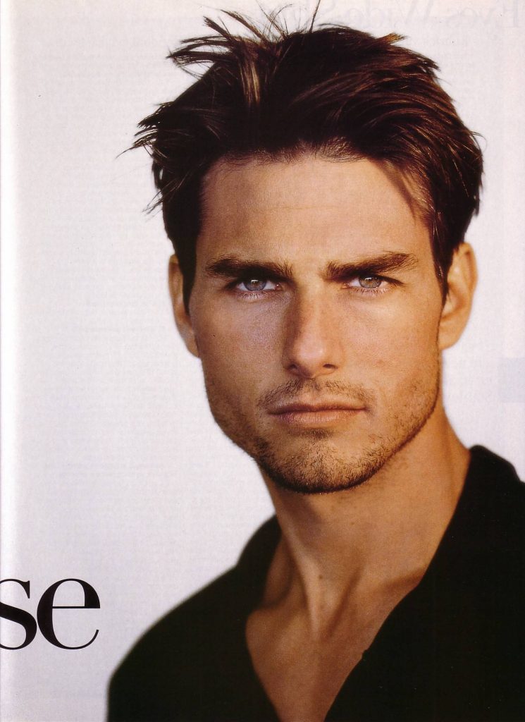 Close-up portrait of Tom Cruise with intense gaze and subtle stubble on bright background wallpaper