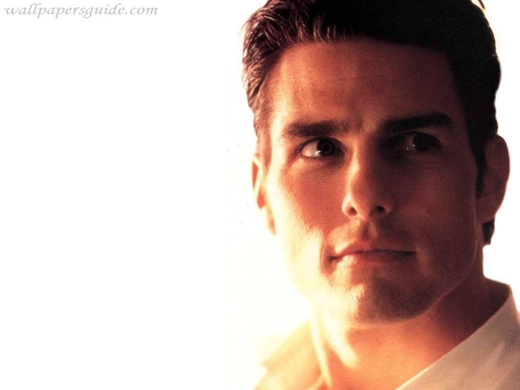 High-resolution portrait of young Tom Cruise with intense gaze warm lighting white background Wallpaper