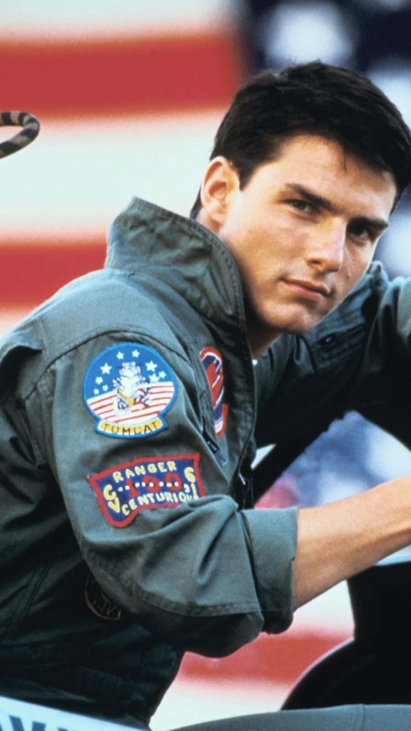 Tom Cruise Top Gun wallpaper wearing olive flight jacket with patches American flag background