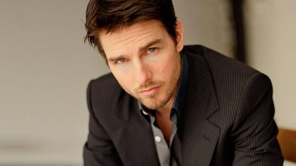 Tom Cruise portrait in dark pinstripe suit intense green eyes handsome cinematic wallpaper background