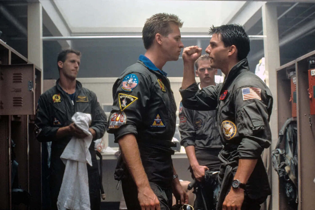 Tom Cruise as Pete Mitchell faces rivals in locker room scene from Top Gun flight suits wallpaper
