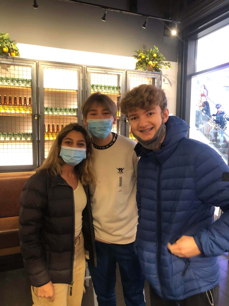 TommyInnit in blue puffer jacket with fans indoor candid group photo beverage shelves background Wallpaper