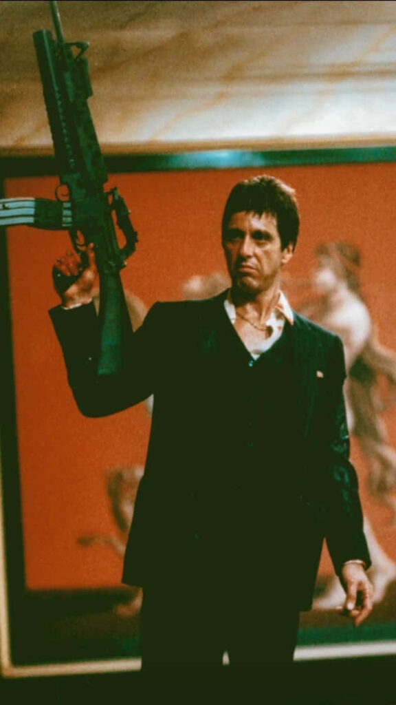 Tony Montana with machine gun in hand iconic Scarface wallpaper of underworld reign background