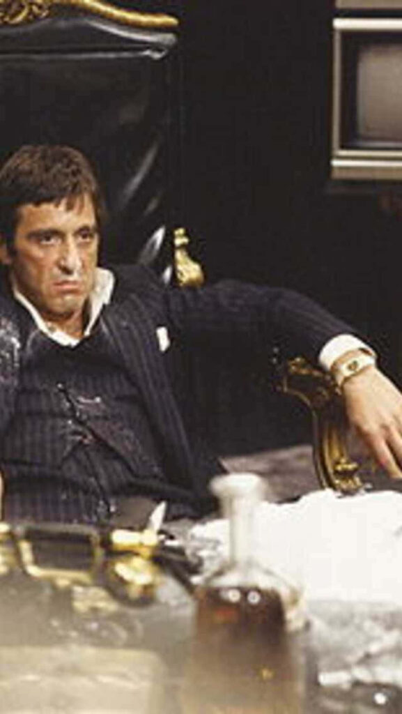 Tony Montana in luxurious chair tense dramatic scene from classic Scarface movie wallpaper