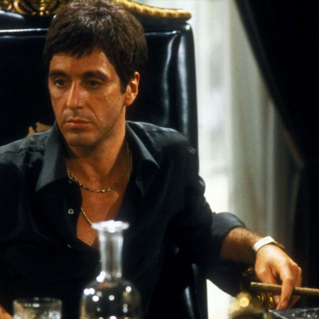 Tony Montana Scarface wallpaper sitting confidently in luxurious chair symbolizing Miami takeover