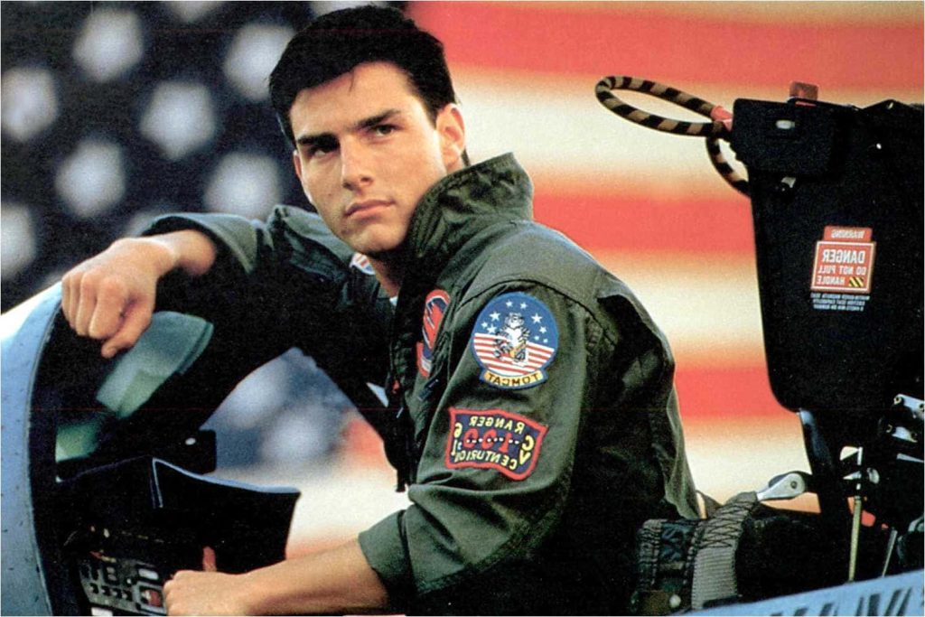 Tom Cruise as Maverick in fighter jet cockpit with American flag Top Gun wallpaper background