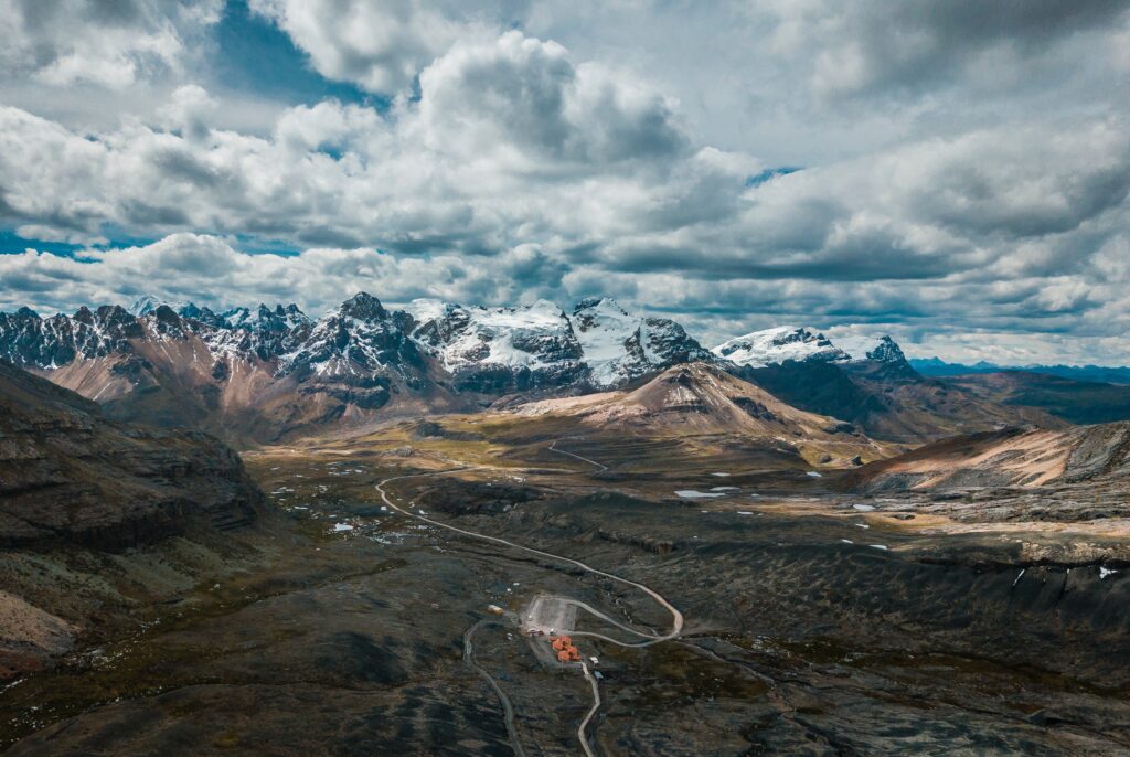 Top view of Peruvian mountains with rugged peaks winding roads and snow-capped summits wallpaper