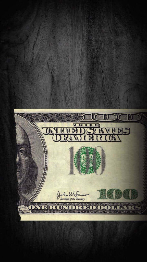 Shredded Fortune: A Striking 100-Dollar Bill Fragment on a Sleek Wooden Table - Ideal Phone Wallpaper