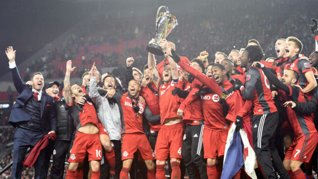 Toronto FC players celebrating MLS Cup 2017 victory in vibrant red uniforms at packed stadium Wallpaper