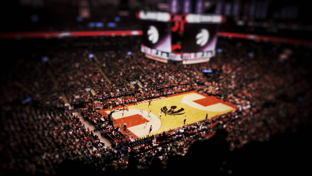 Tilt-shift aerial view of Toronto Raptors basketball game at Scotiabank Arena with court logo Wallpaper