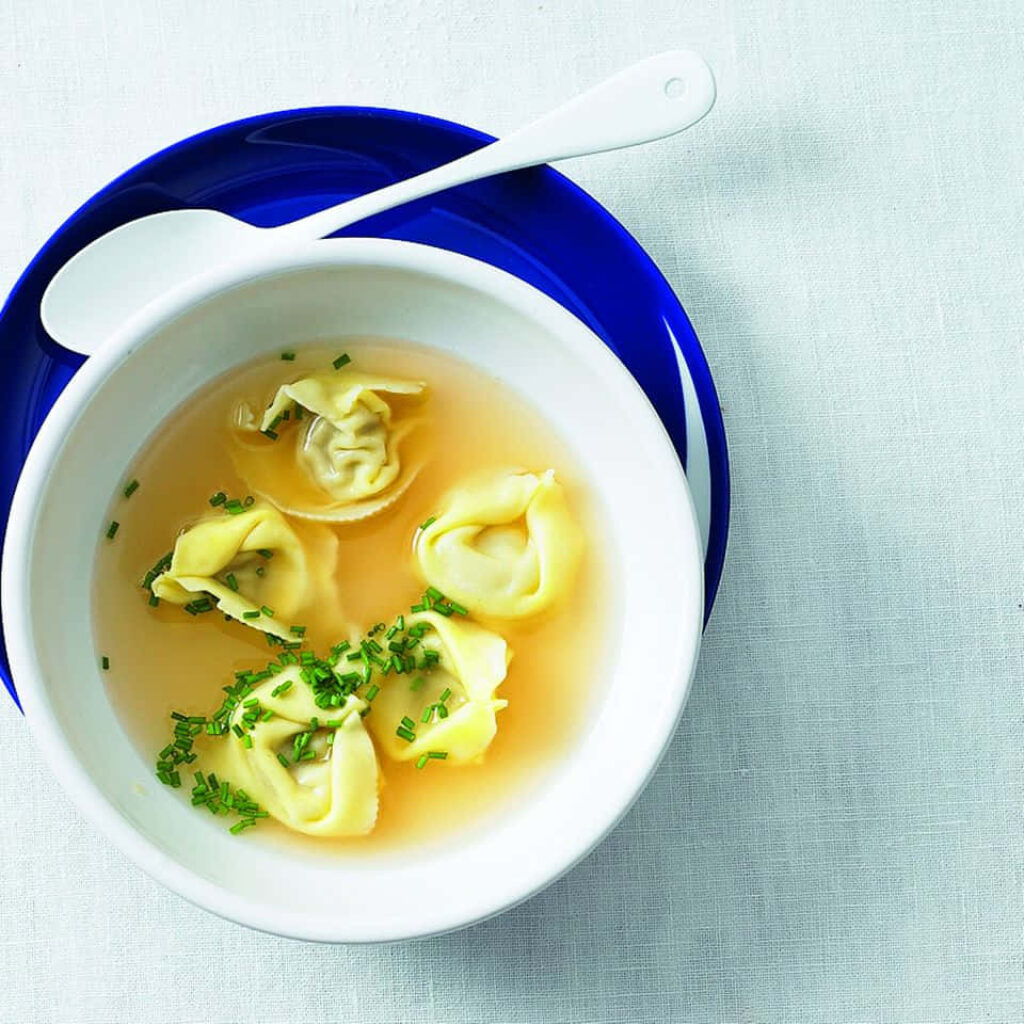 Tortellini in Brodo: A Delicious Bowl on Blue Plate - Wallpaper