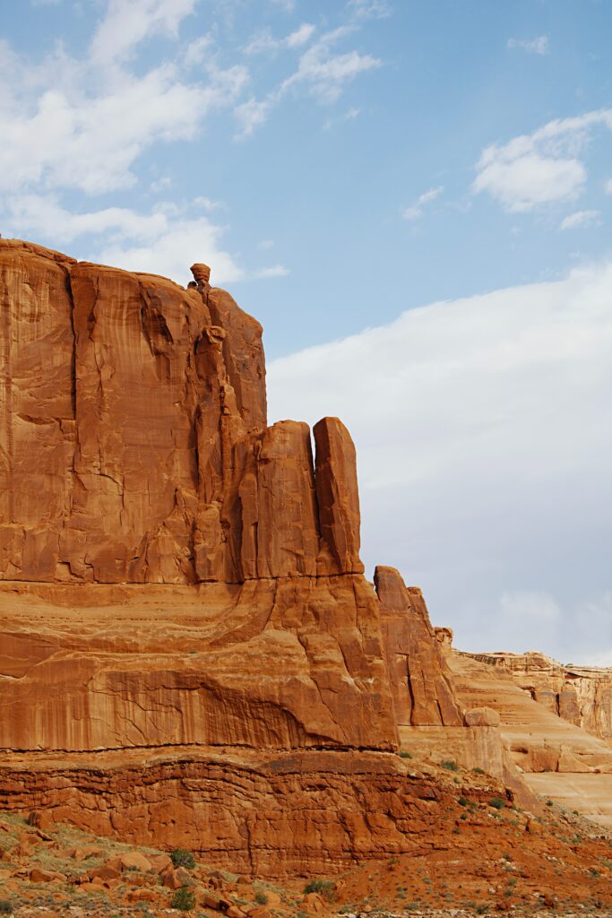Towering canyon rocks and rugged mountains in sandy hues under clear blue sky wallpaper background