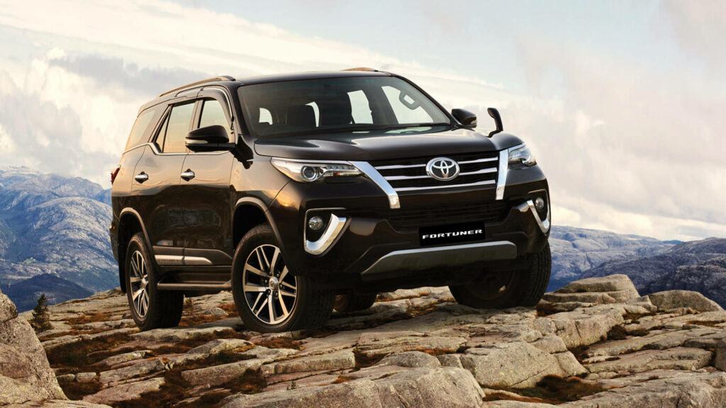 Toyota Fortuner BS6 parked on rocky terrain with scenic mountains showcasing bold SUV design Wallpaper