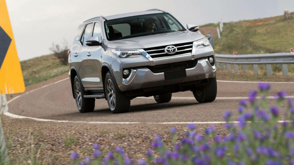 Toyota Fortuner VXR 2019 driving on curving road showcasing robust design and strong presence Wallpaper