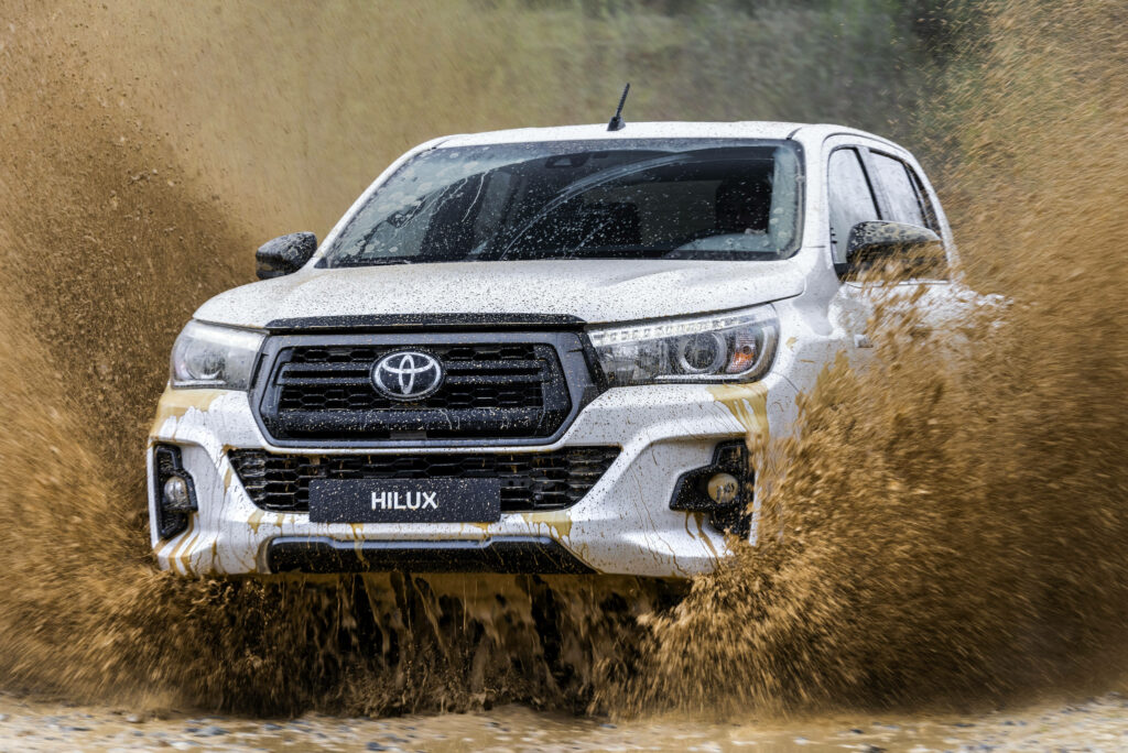 Toyota Hilux off-road in muddy water rugged truck 4K wallpaper showcasing strength and durability