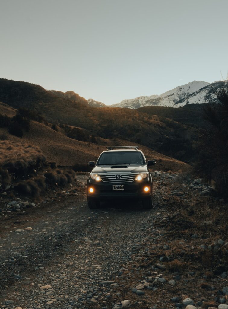 Toyota SUV Front View: Adventure on Rugged Roads with Scenic Hills Wallpaper