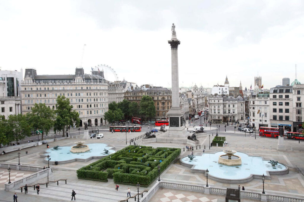 Trafalgar Square with Nelson Column red double-decker buses and classic London architecture wallpaper