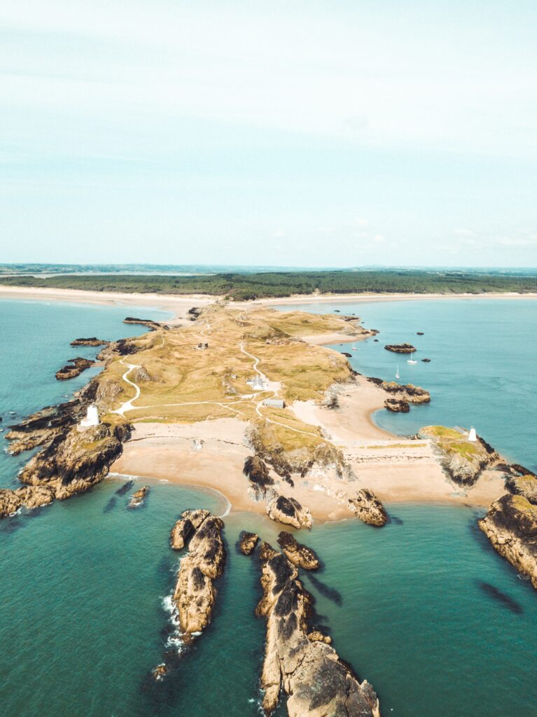 Aerial view of rugged island with winding coastal paths sandy beaches and calm turquoise sea wallpaper