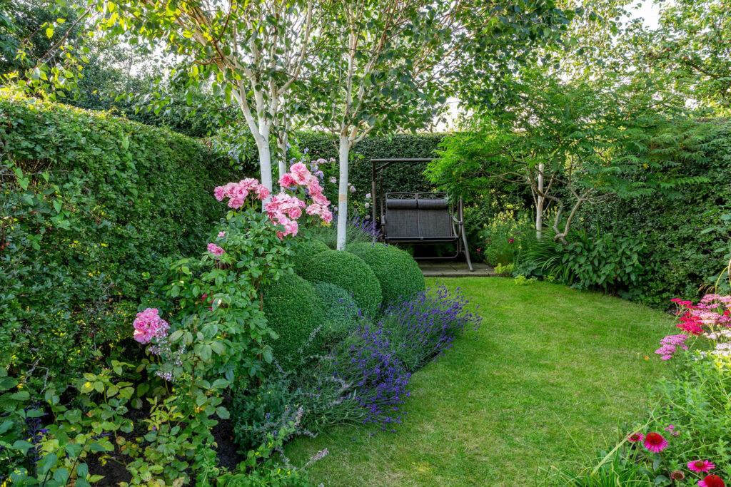 Tranquil Backyard Garden Wallpaper: Greenery & Cozy Swing Retreat