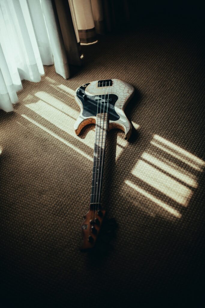 Tranquil Bass Guitar Wallpaper on Textured Carpet with Soft Light