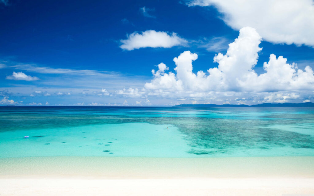 Tranquil Beach: Crystal-Clear Waters & Fluffy Cloud Sky Background Wallpaper