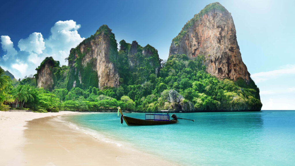 Tranquil Beach Scene Wallpaper with Long-Tail Boat & Mountains