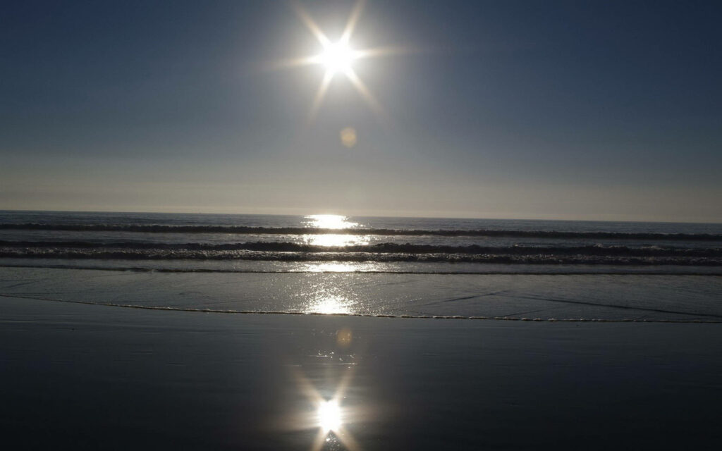 Relaxing Beach Desktop Wallpaper: Sunlit Waves & Reflective Horizon