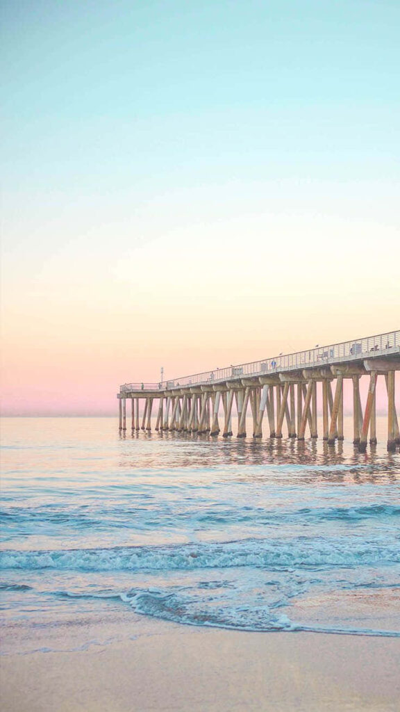 Tranquil Beachscape Wallpaper: Pier at Sunset with Soft Pastel Hues