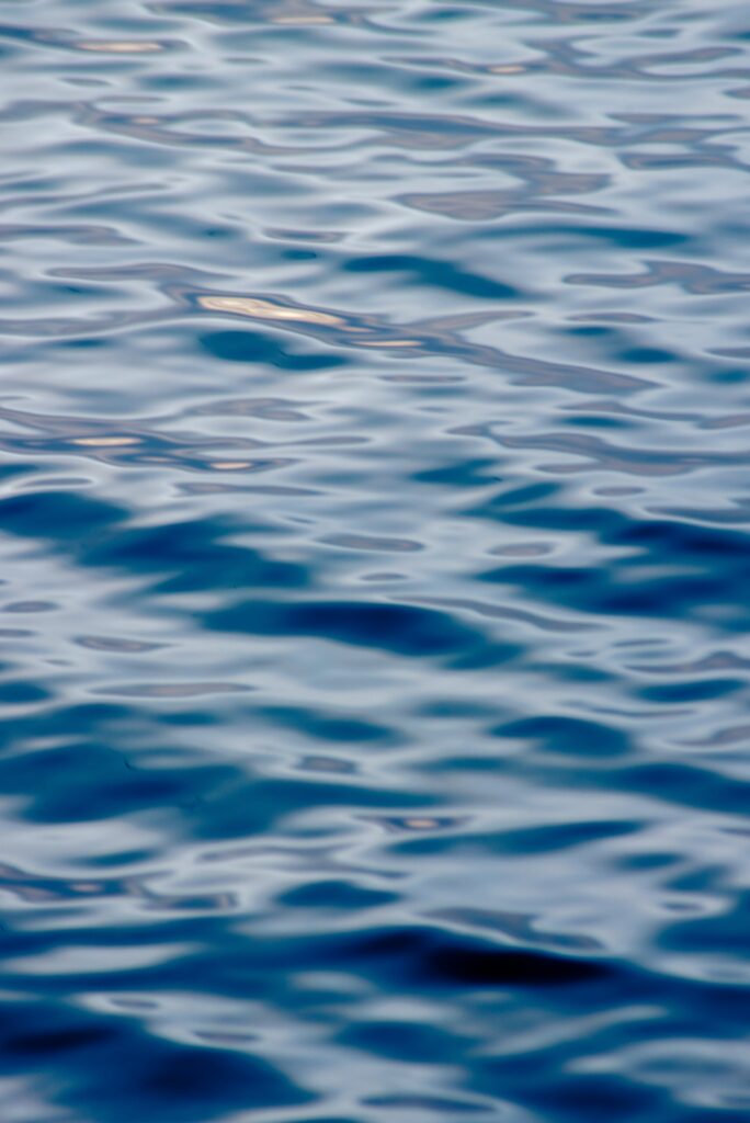 Tranquil blue water wallpaper with gentle waves ripples reflecting serene natural movement