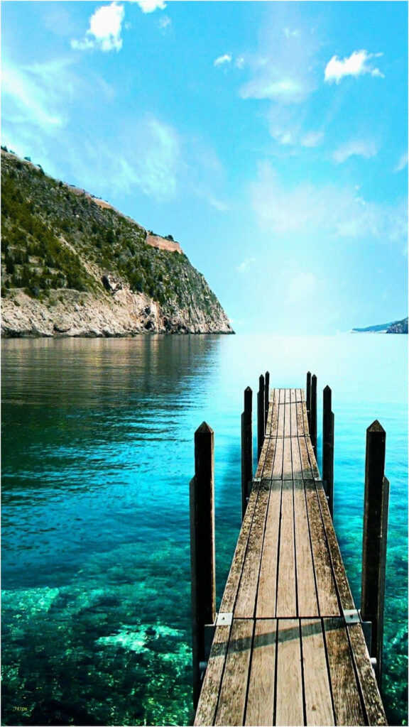 Serene wooden pier over turquoise waters with lush hills in Bora Bora relaxing vacation view Wallpaper