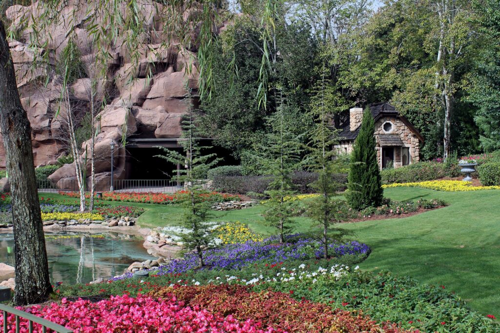 Vibrant Canadian garden wallpaper with colorful flowerbeds pond stone pavilion and lush green lawn