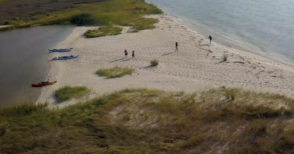 Serene Aerial View of Chesapeake Bay Beach with Calm Waters & Kayaks Wallpaper