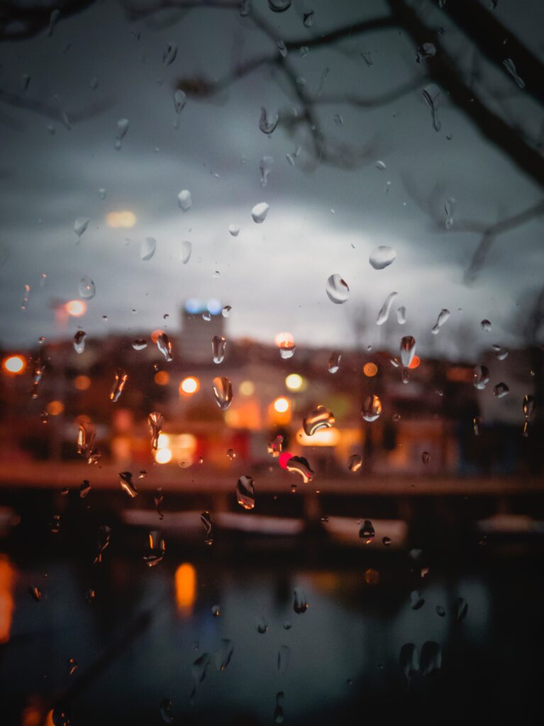 Tranquil Cityscape Wallpaper: Blurred Rain-Splattered Window View