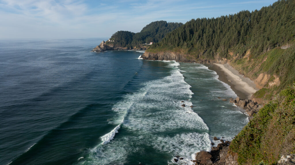 Coastal landscape wallpaper with tranquil bay lush green trees cliffs deep blue sea sandy shore