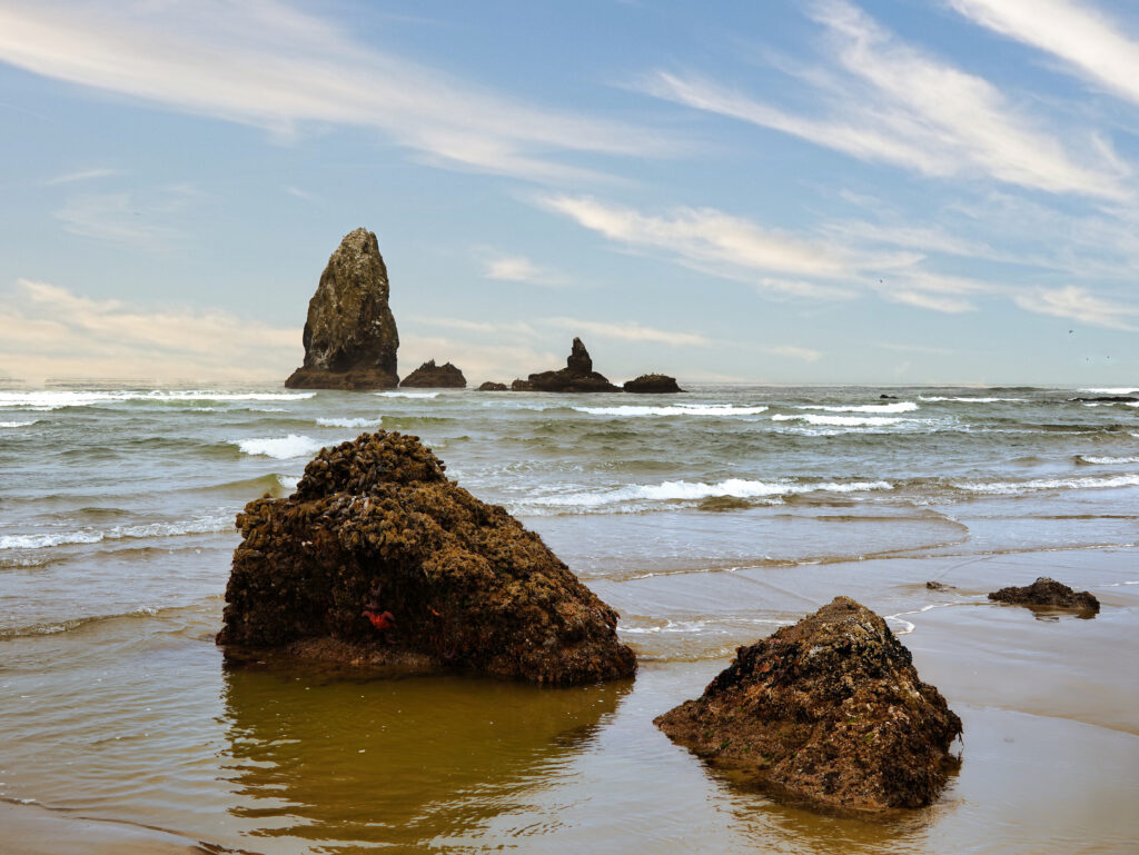 Tranquil coastal landscape with rugged stones and rock formations under a blue sky wallpaper background