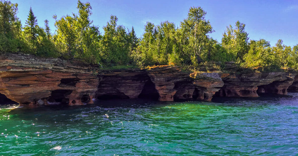 Scenic Coastal Wallpaper: Lush Greenery & Tranquil Blue Waters