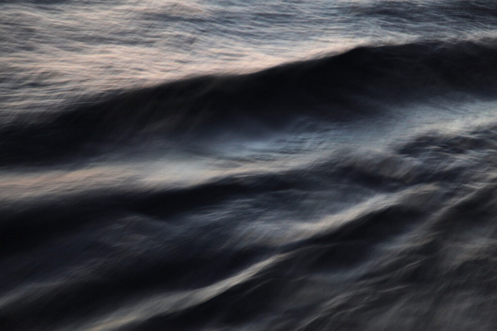 Abstract dark blue sea waves wallpaper with soft relief and light reflections evoking tranquility