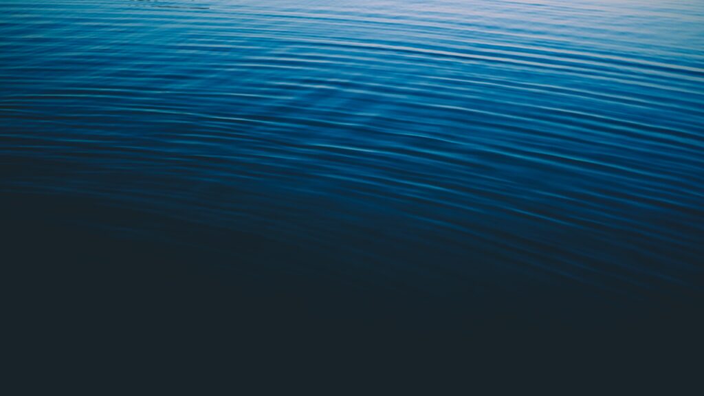 Tranquil deep blue sea wallpaper with gentle ripples creating a soothing minimalist background