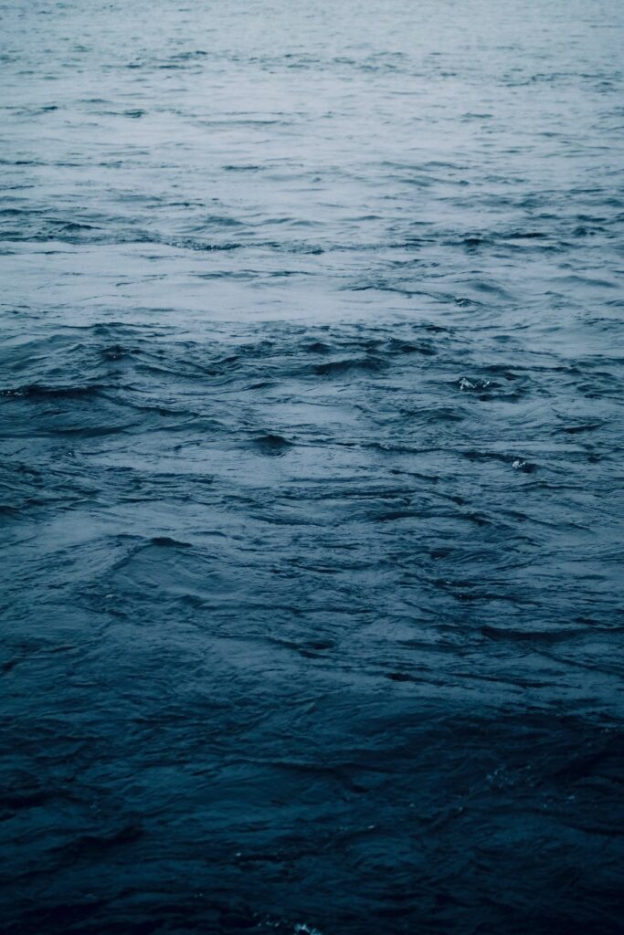Tranquil deep blue sea wallpaper with gentle waves and subtle ripples for calming background