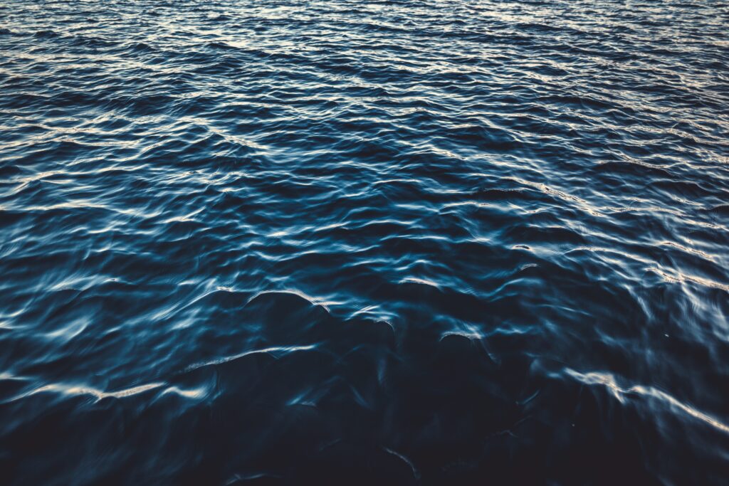 Calm deep blue sea wallpaper with gentle waves ripples and subtle reflections for peaceful ambiance