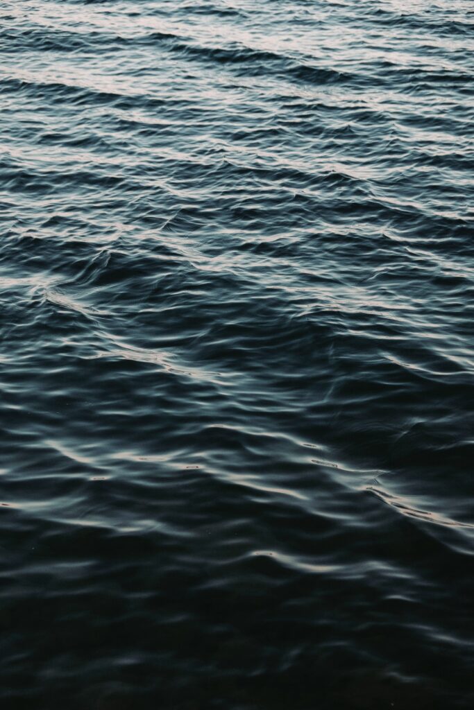 Deep blue waves with gentle ripples create a calming and immersive aquatic wallpaper background