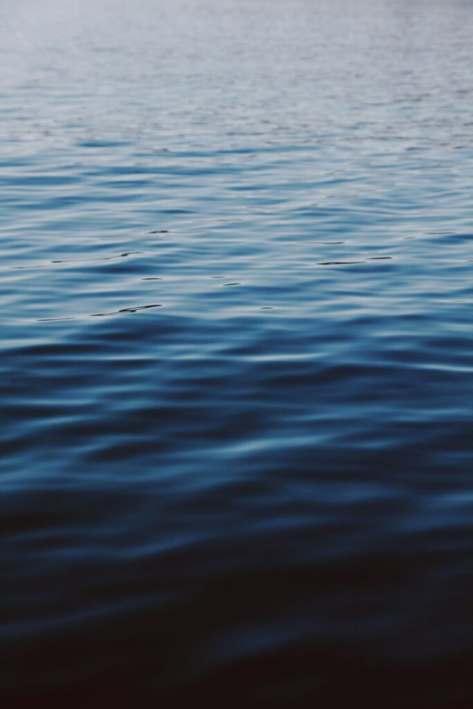 Tranquil deep blue water with gentle waves and smooth gradients serene wallpaper background