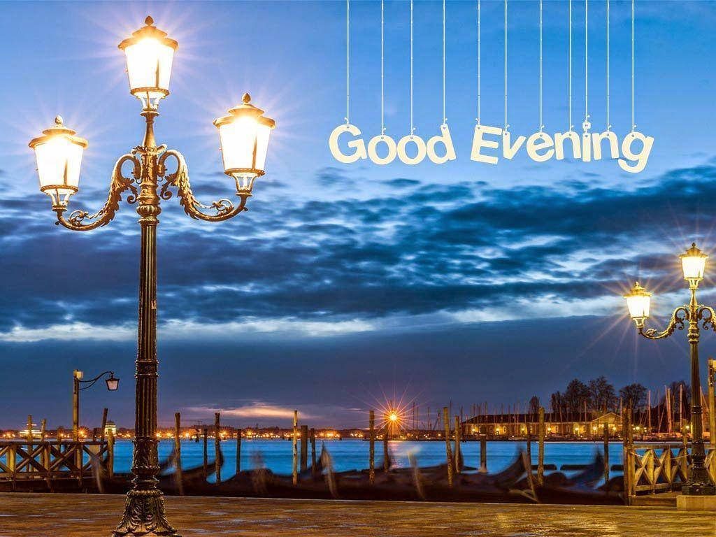 Tranquil Good Evening wallpaper with glowing vintage lamps by calm waterfront at dusk sky
