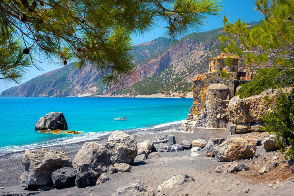 Tranquil Greek Beach Wallpaper: Crystal Waters & Rugged Cliffs