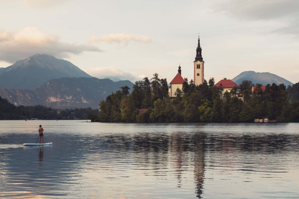 Tranquil Lake Bled Sunset Wallpaper: Paddler & Church of Assumption